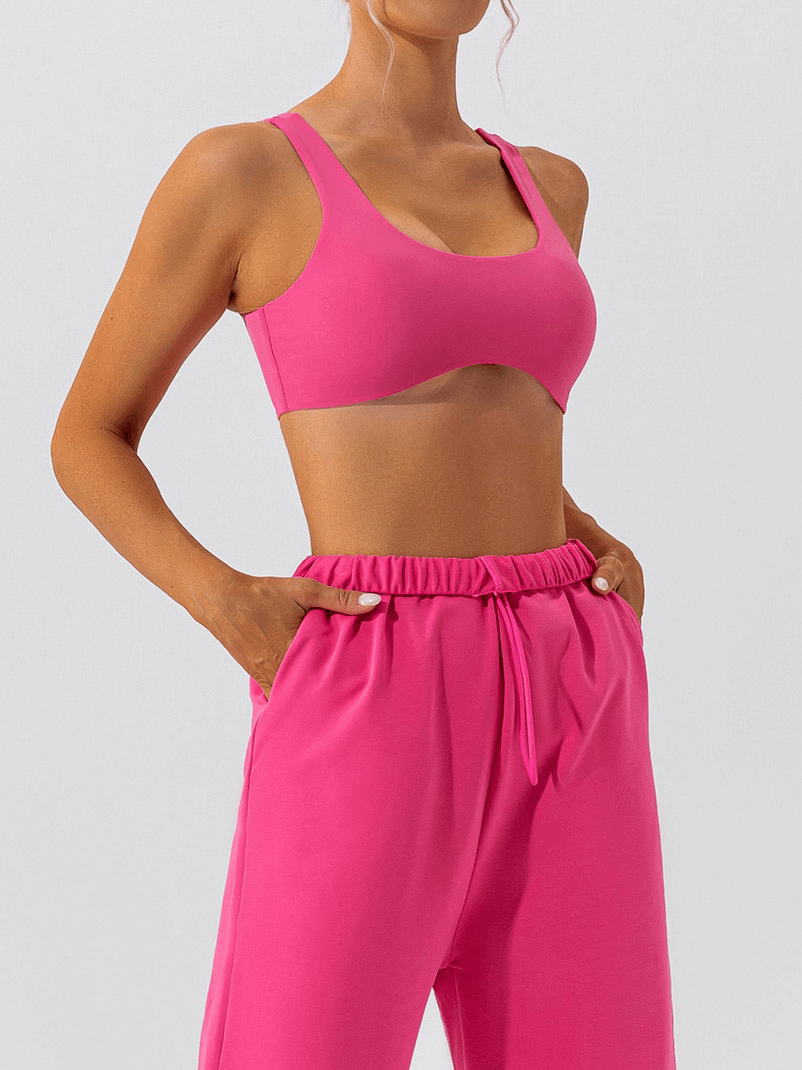 Woman wearing a pink seamless sports bra and matching pants, ideal for gym workouts and yoga sessions. Style SF1314.