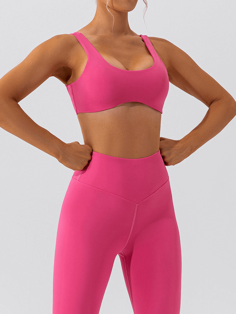 Woman wearing pink seamless sports bra and leggings, perfect for gym workouts and yoga, highlighting breathability and comfort.