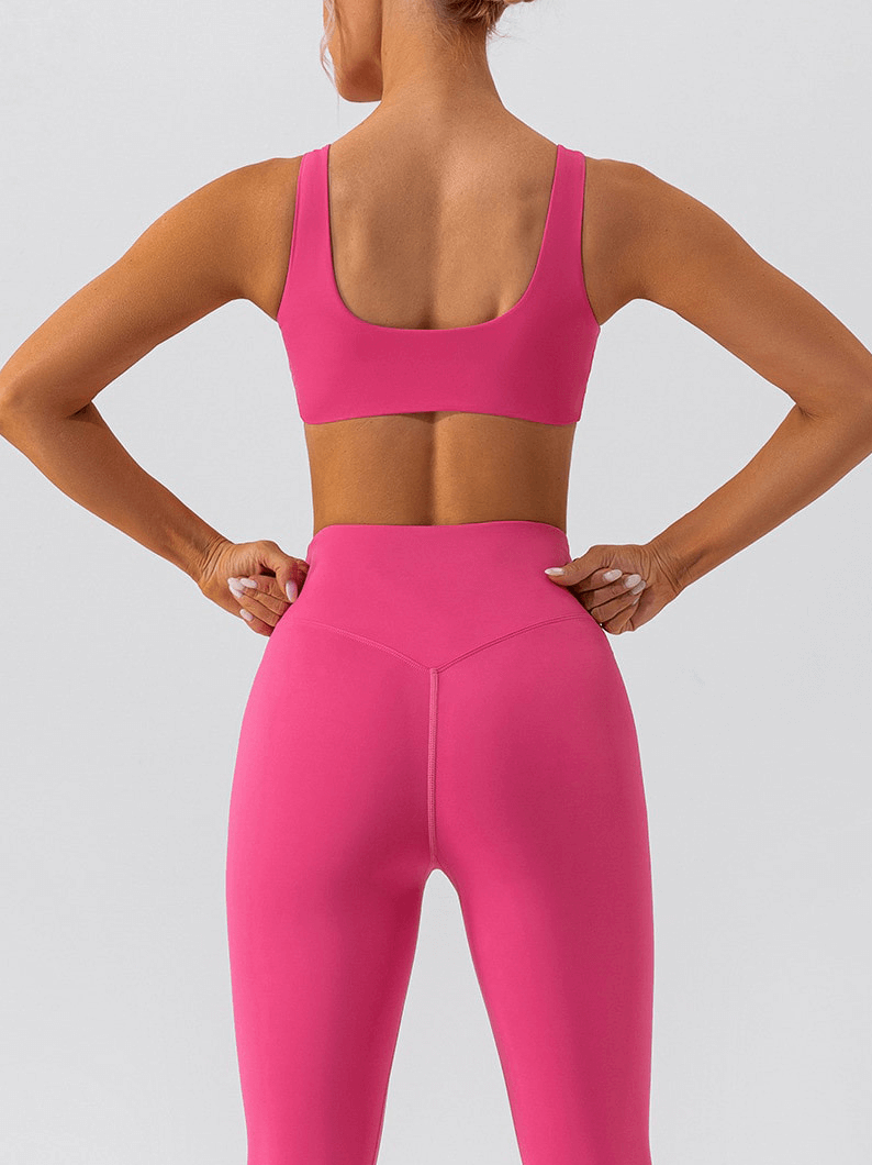Woman wearing a pink gym workout breathable seamless sports bra and leggings, showcasing back design for ultimate comfort and style.