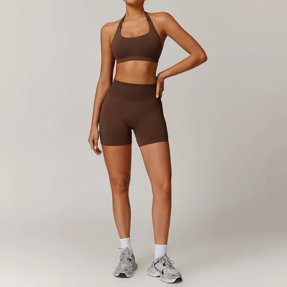 Model wearing brown halter sports bra and seamless high-waisted shorts set, perfect for yoga and gym workouts. Stylish and supportive activewear.