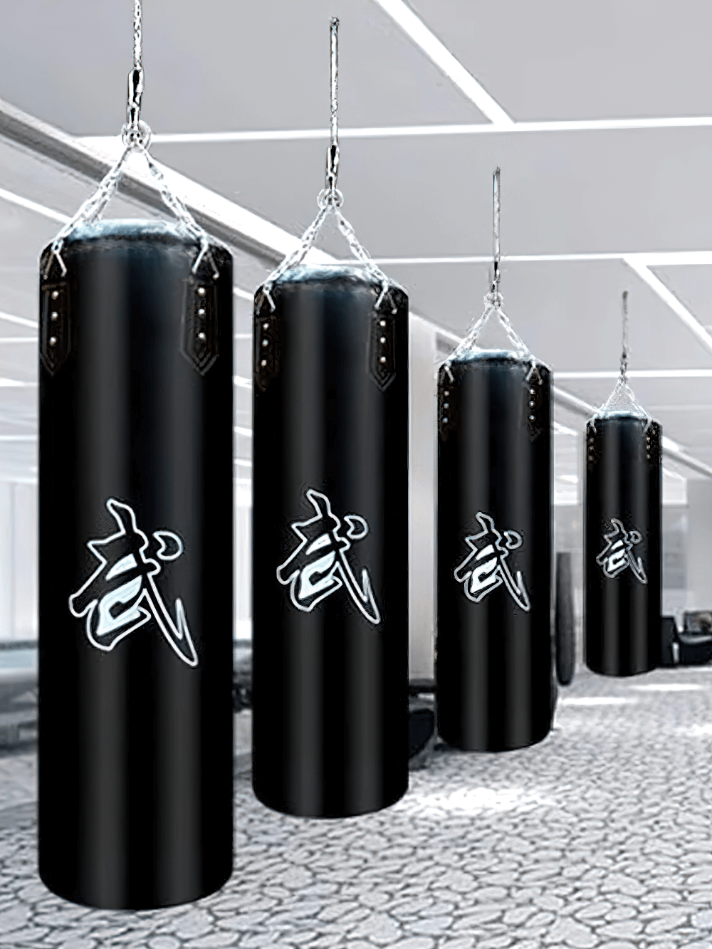 Hanging black punching bags with martial arts symbols for boxing, kickboxing, and MMA training in a modern gym.