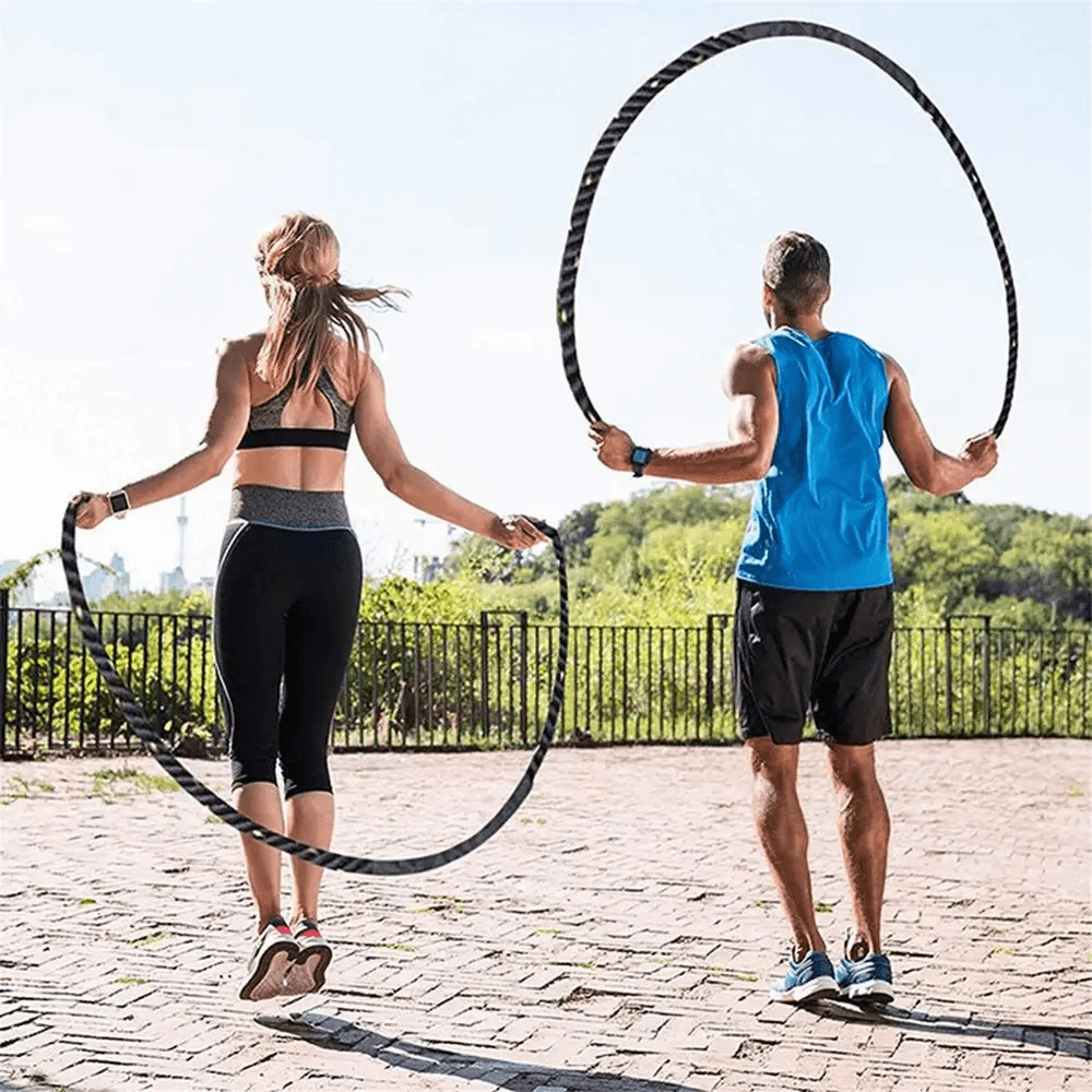 Two people exercising outdoors with heavy weighted jumping ropes for fitness and boxing training.