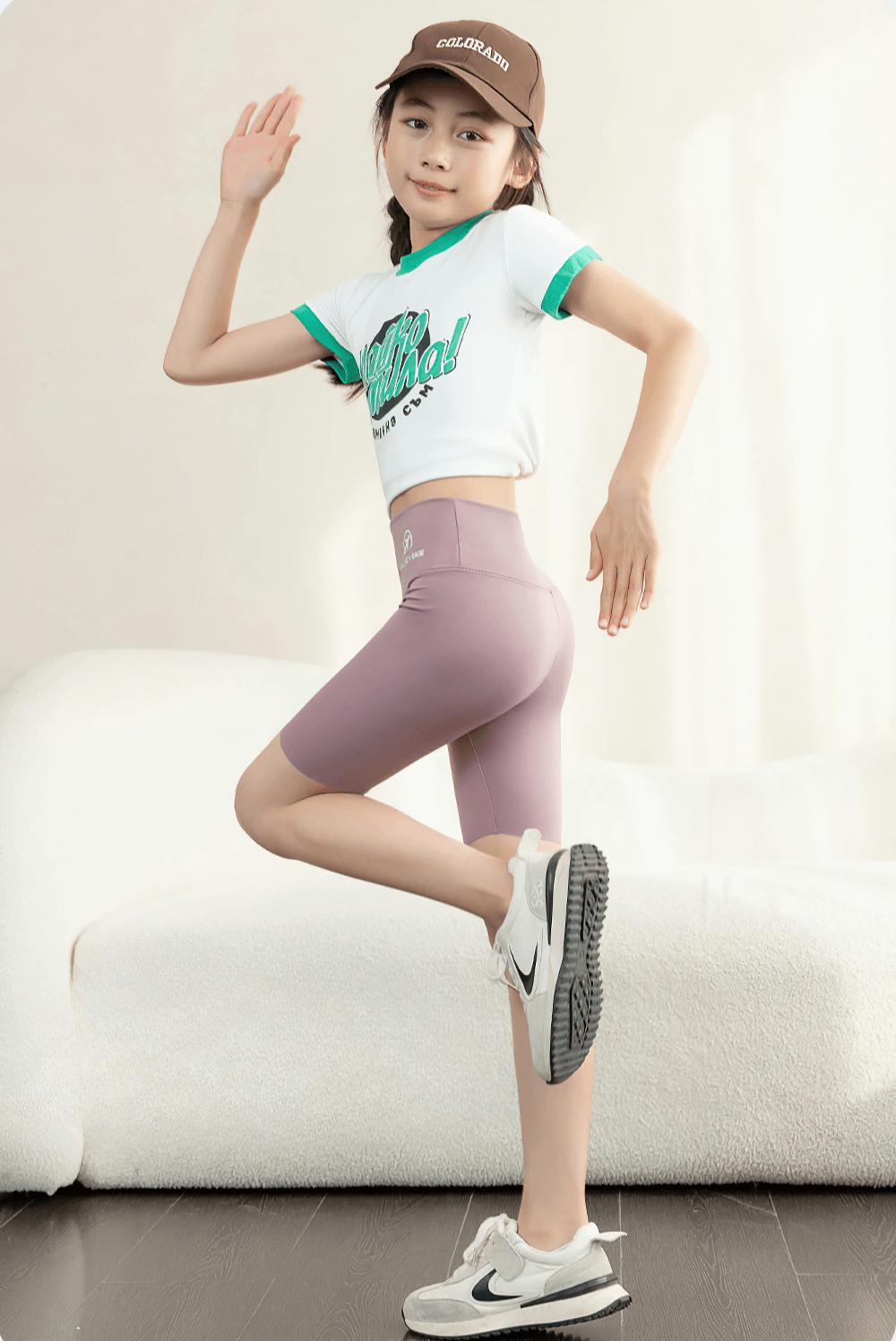 Young girl poses in High Elasticity Girls Sports Shorts for Training - SF3765, showcasing freedom of movement and comfort in active wear.