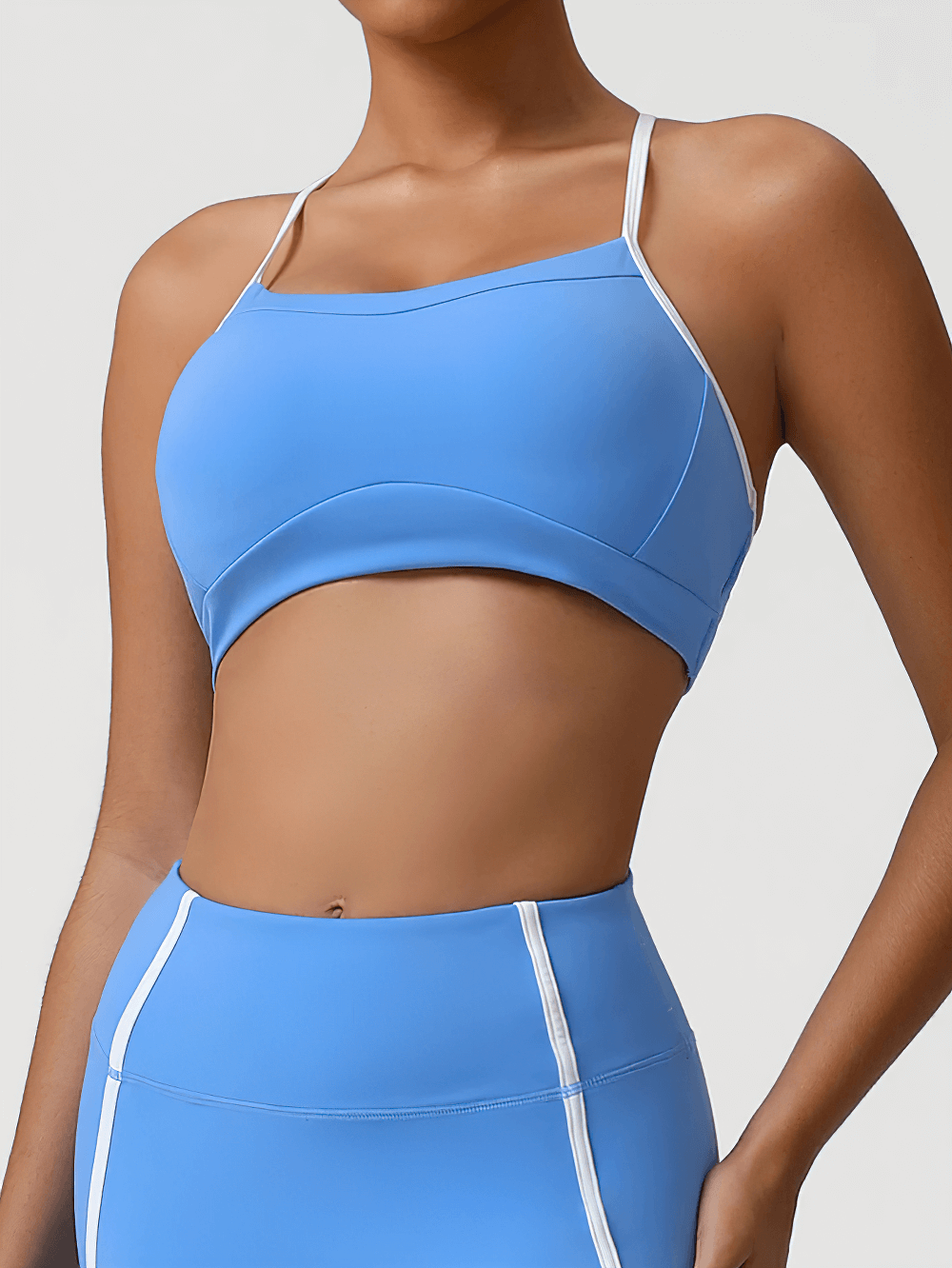Woman wearing High Impact Racerback Sports Bra with Contrast Trim - SF4063 in blue, showcasing its sleek design and supportive fit