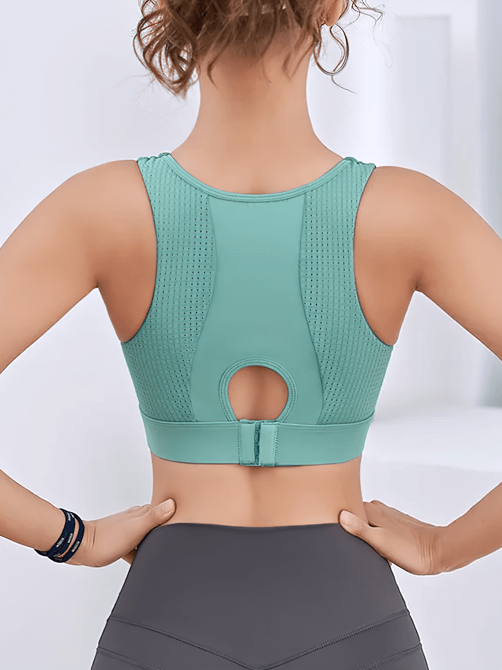 Back view of teal sports bra with quick-dry fabric and stylish open back design. Ideal for high-impact activities.