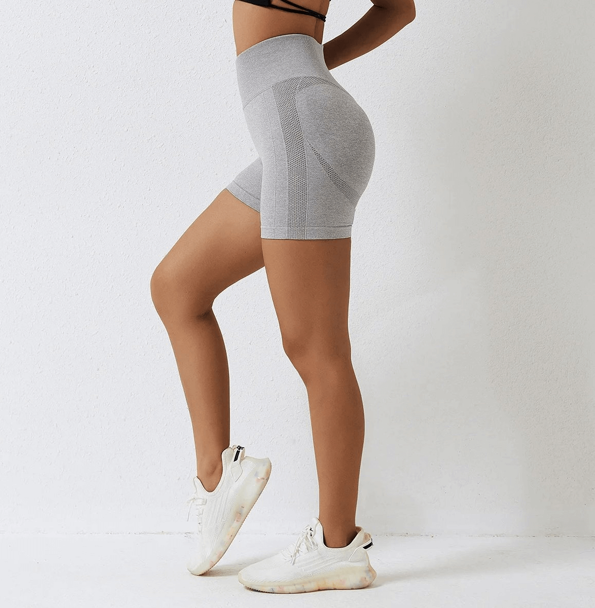 Woman wearing high-performance nylon spandex yoga shorts in gray, showcasing versatile athletic fit for yoga, running, or cycling.