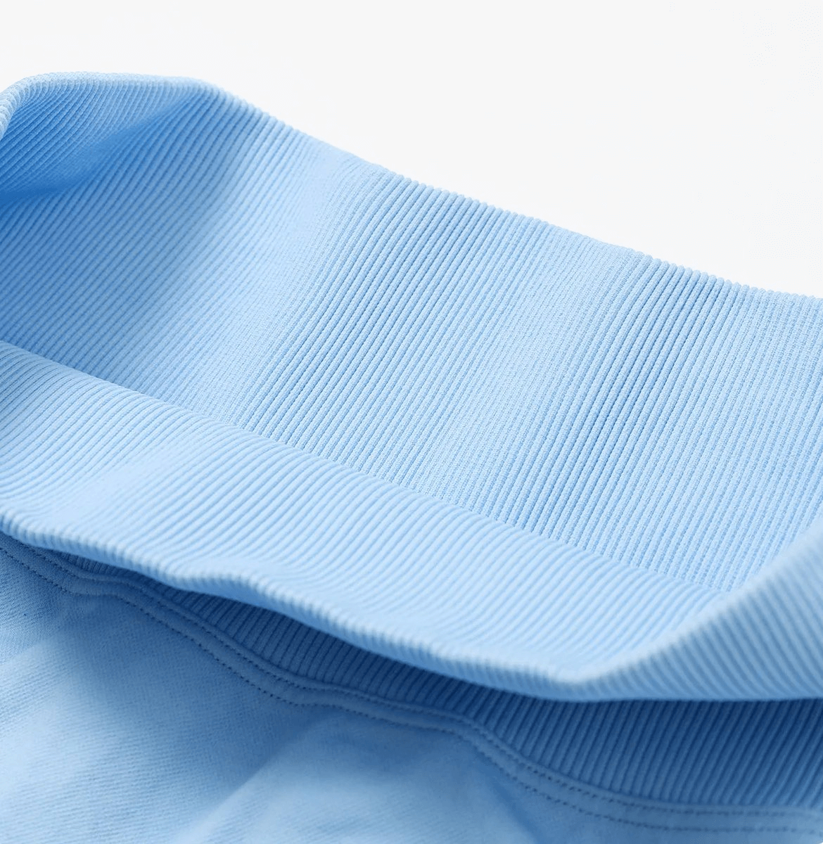 Close-up of blue high-performance nylon spandex yoga shorts waistband, showcasing ribbed texture and stretch for active comfort.