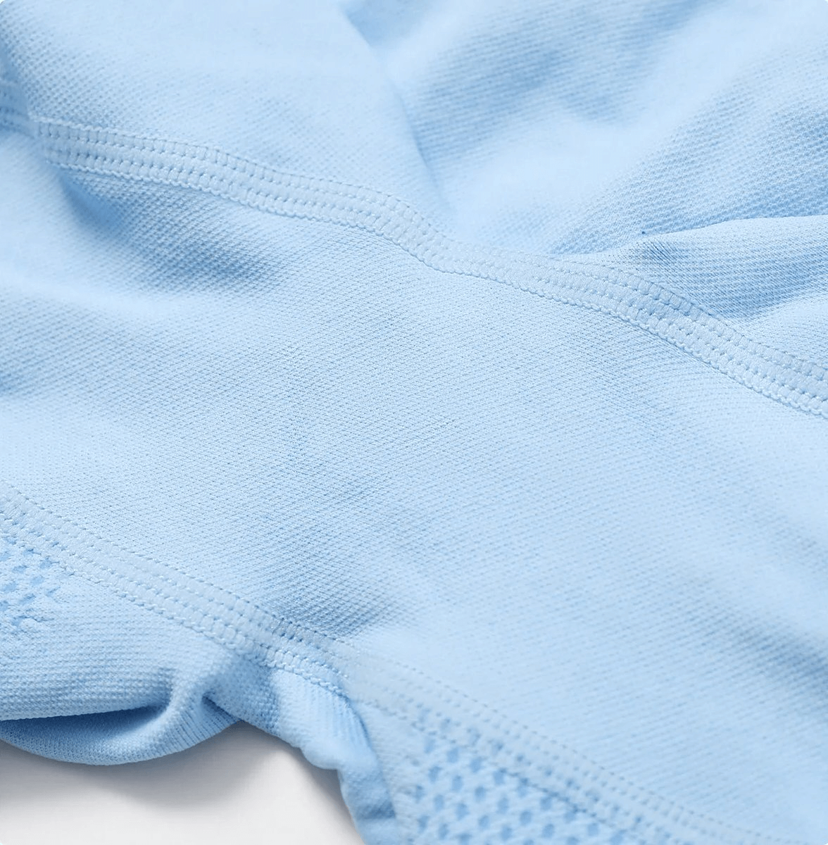 Close-up of blue high-performance nylon spandex yoga shorts fabric, showcasing stitching and texture detail.