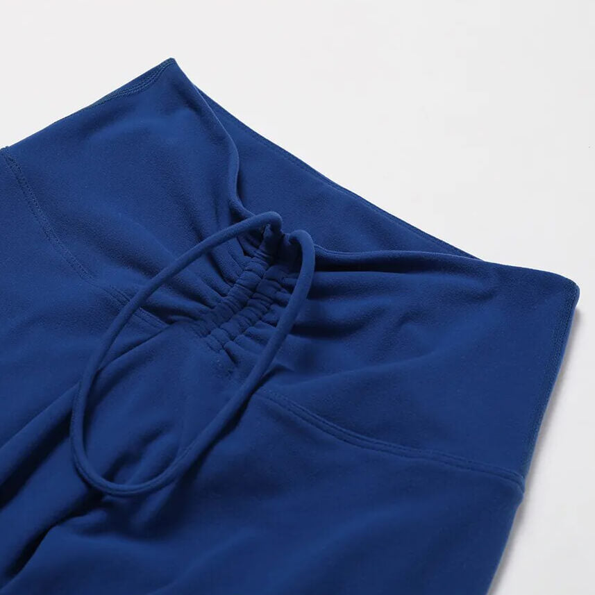 Close-up of high waist leggings in blue, showcasing stretchy fabric and drawstring detail for comfortable yoga or fitness sessions.