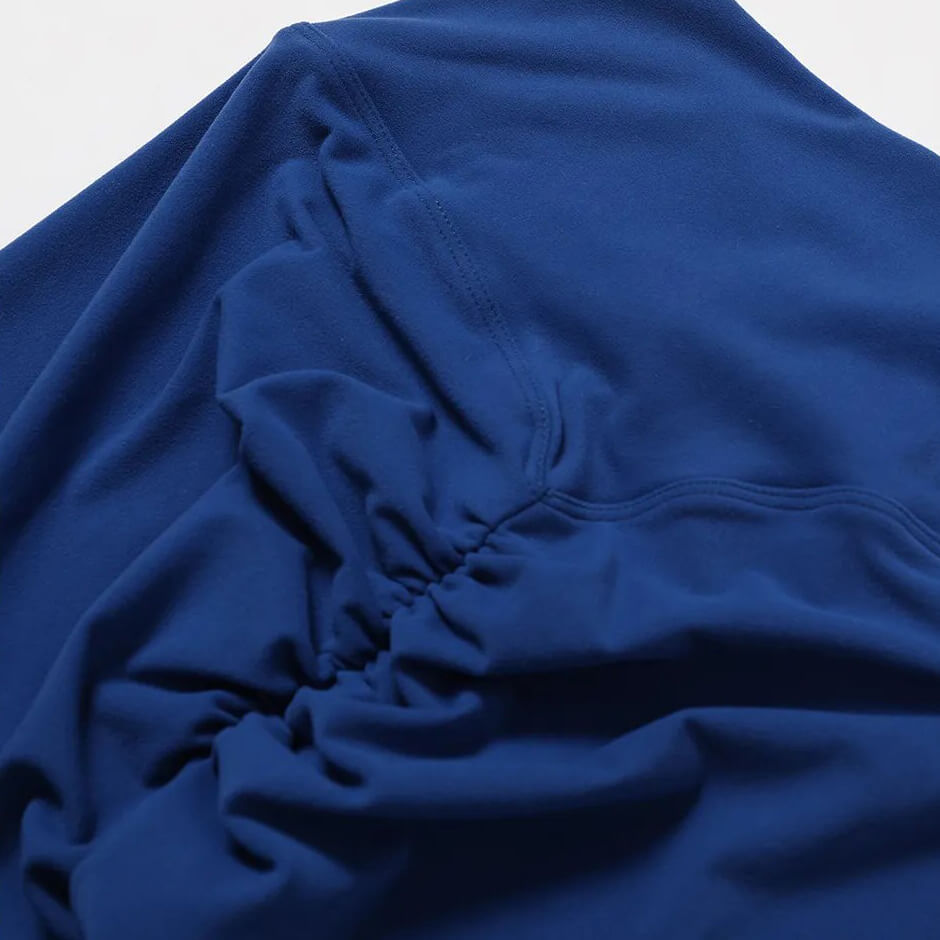 Close-up of blue ruched fabric on high waist leggings, part of a yoga set made from breathable, quick-drying nylon material.