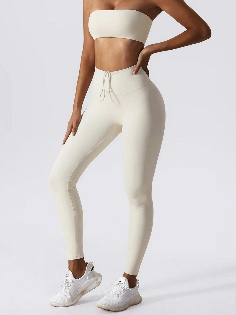 Woman modeling high waist leggings and push up sports bra yoga set, perfect for fitness. Features breathable, anti-wrinkle nylon fabric.