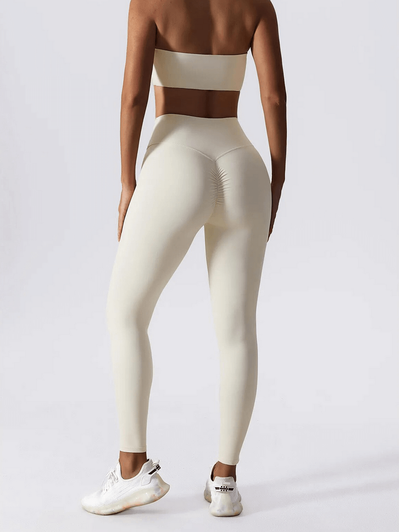 Back view of woman wearing beige high waist leggings and sports bra yoga set, showing comfort and style.