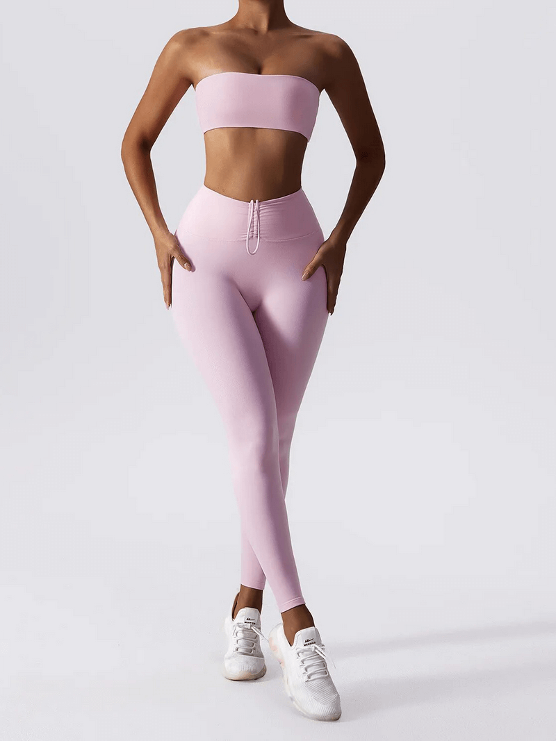 Woman wearing pink high waist leggings and push-up sports bra yoga set, ideal for fitness, made from breathable, quick-drying fabric.