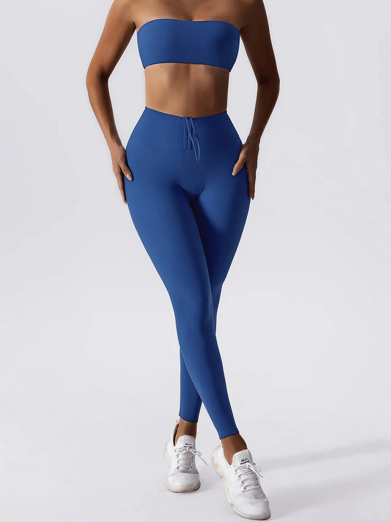 Woman wearing blue high waist leggings and push up sports bra yoga set, showcasing stylish fitness apparel.