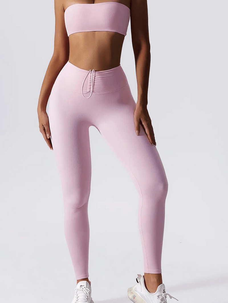 Woman wearing pink high waist leggings and push up sports bra yoga set, ideal for fitness and comfort, made from breathable nylon.