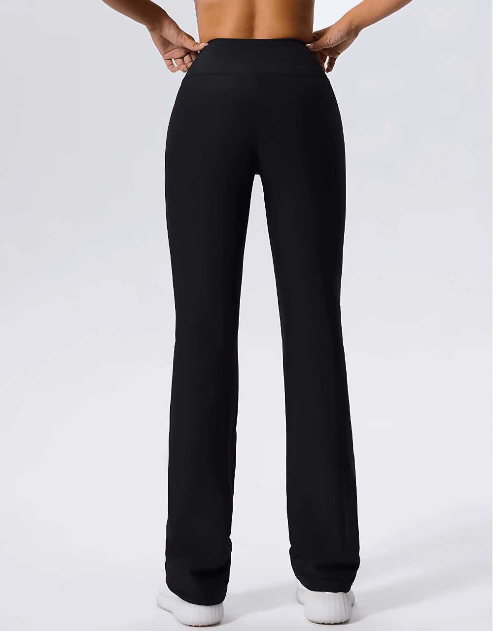 Back view of high-waist ribbed flared yoga pants for women in black, showcasing bell-bottoms and elastic waist, ideal for fitness and style.