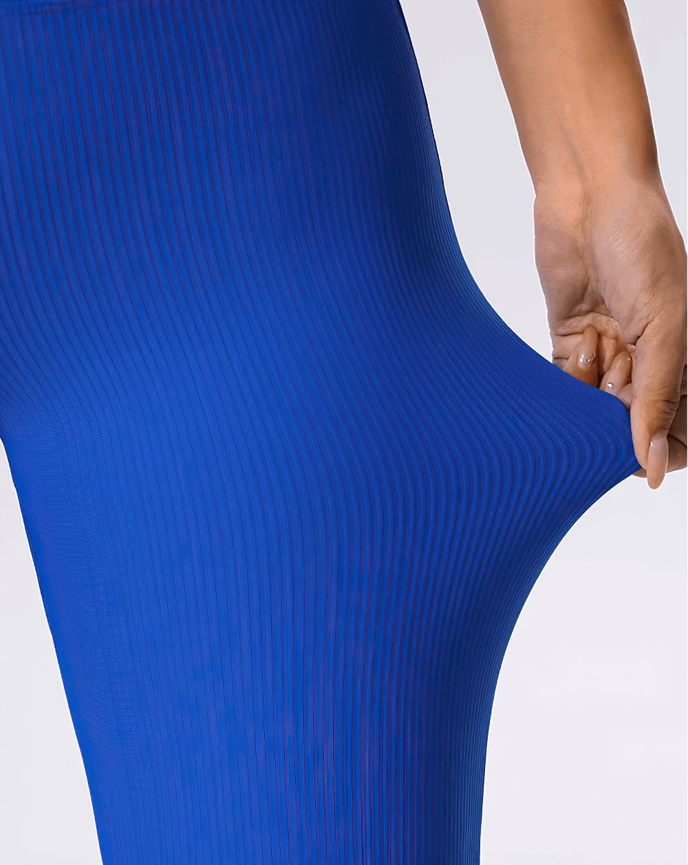 Close-up of hand stretching blue ribbed yoga pants showing texture and flexibility.