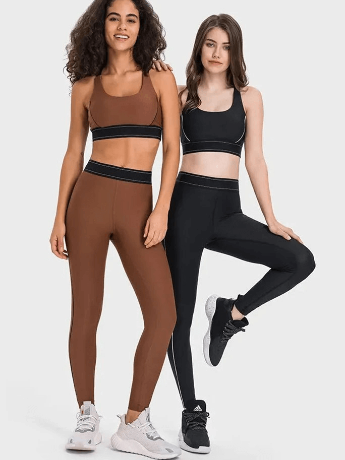 Two women wearing high-waisted gym elastic compression leggings in brown and black, posing in activewear for workouts.