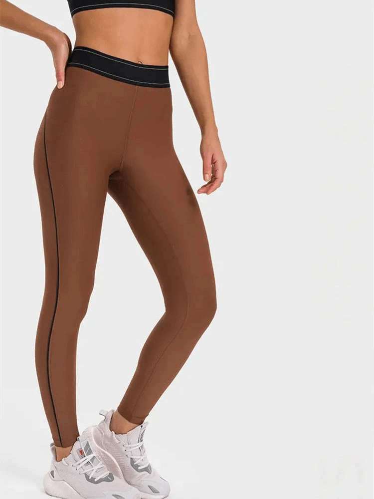 High-waisted brown gym leggings, elastic and snug fit, ideal for yoga and running, providing support and flexibility.