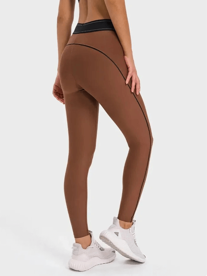 Back view of brown high-waisted gym elastic compression leggings, showcasing stretch and comfort for yoga or running.
