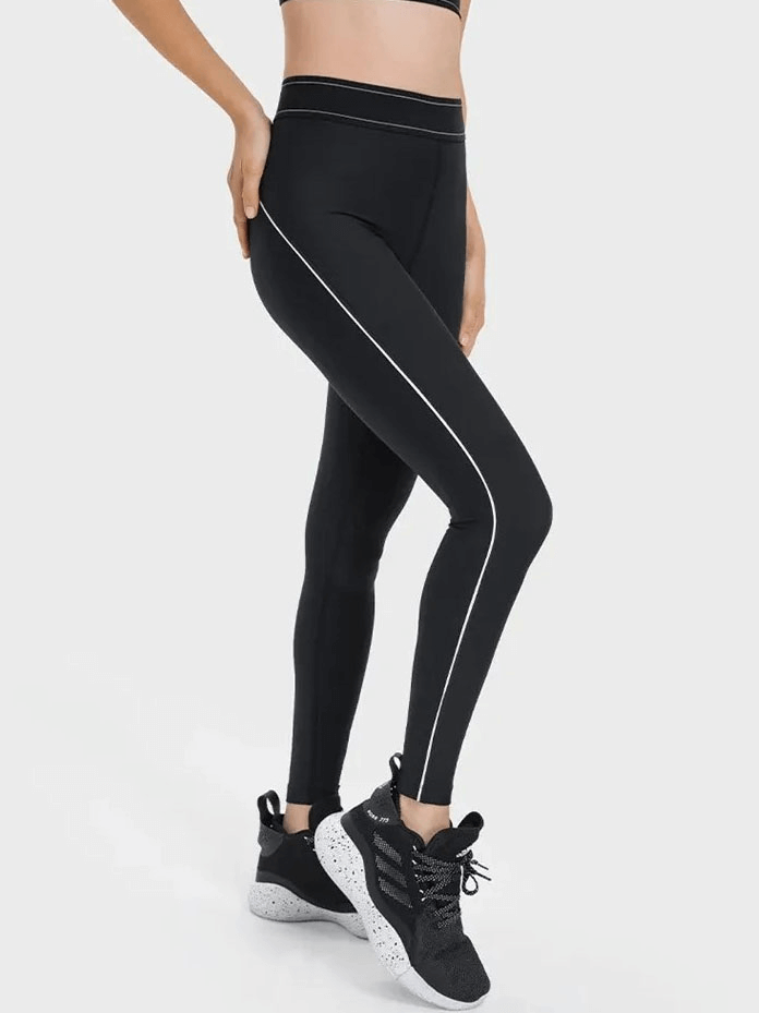 Woman wearing high-waisted gym leggings with elastic compression and sneakers, showcasing flexibility and comfort for workouts.