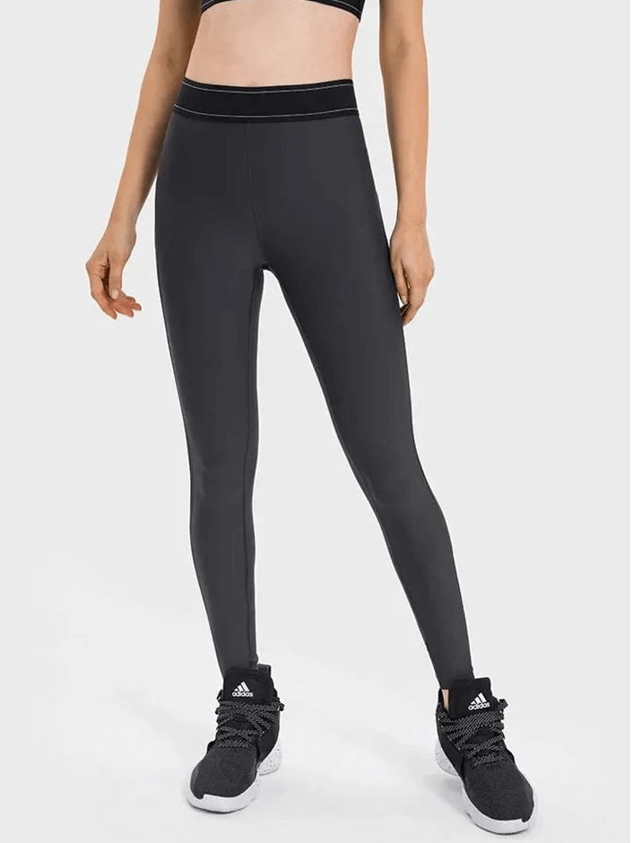 Woman wearing high-waisted gym leggings SF1806, perfect for yoga and workouts, with elastic waist and flexible sweat-wicking fabric.