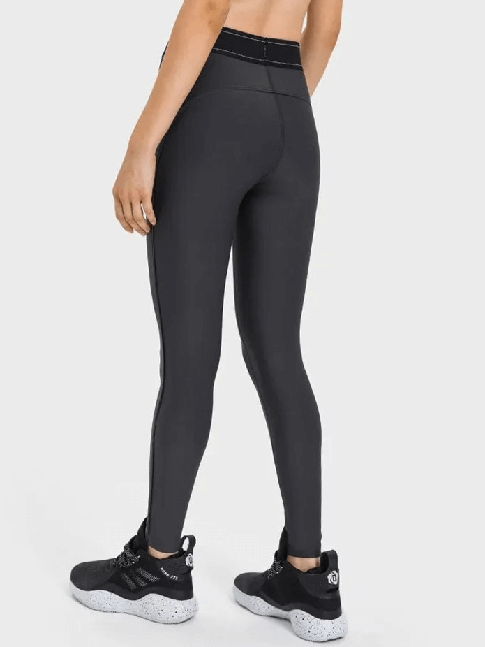 Person wearing high-waisted gym elastic compression leggings, ideal for yoga or running, showing a snug fit and flexible fabric.