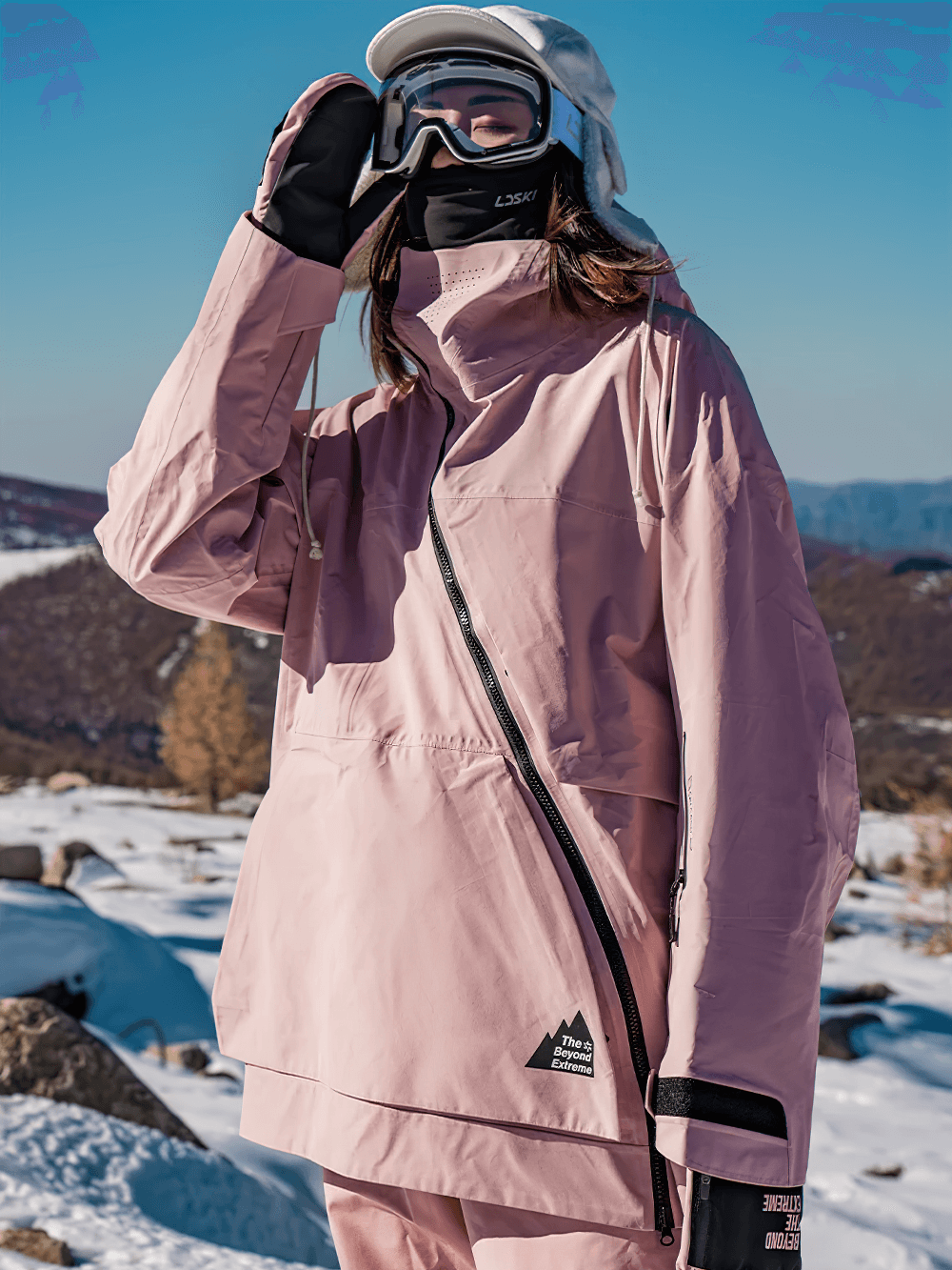 Person wearing pink hooded jacket with diagonal zipper and hood in snowy landscape.