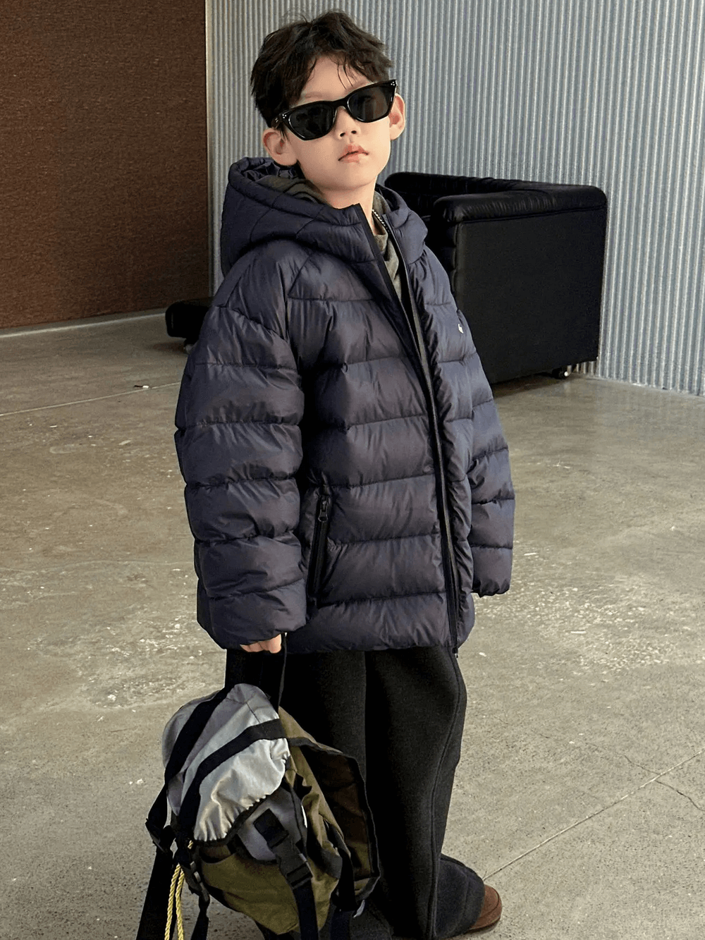 Boy wearing Hooded Puffer Jacket with Zipper and Insulation - SF3640, showcasing winter fashion with stylish sunglasses and bag.