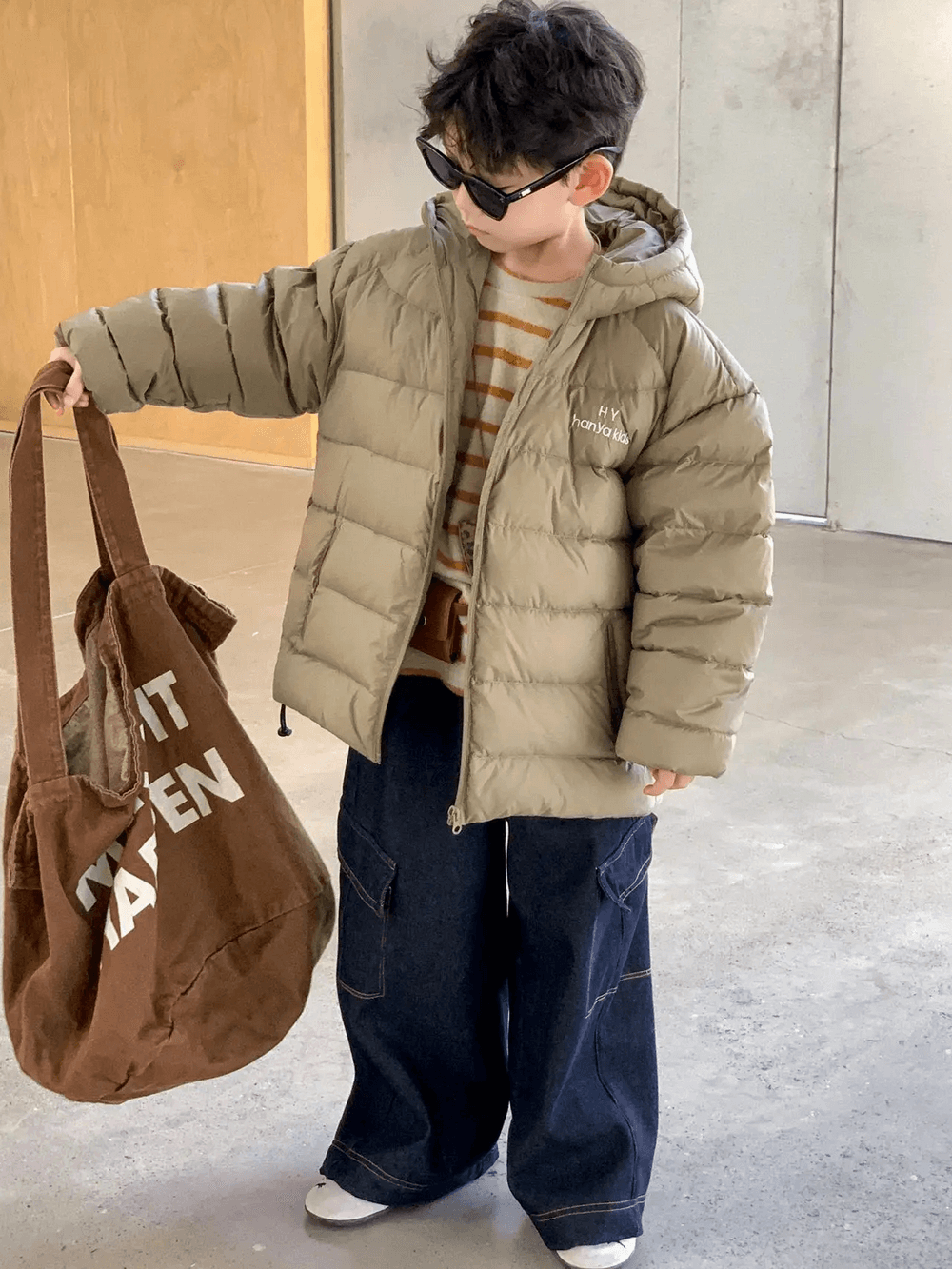 Boy in Hooded Puffer Jacket with Zipper and Insulation - SF3640 wearing sunglasses, holding a bag, demonstrating warm winter fashion.