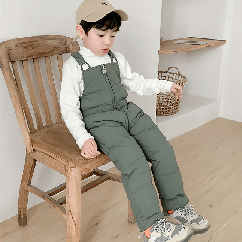 Young child wearing Insulated Snow Bib Pants for Boys and Girls - SF3731, sitting on chair indoors, showcasing winter overalls style.