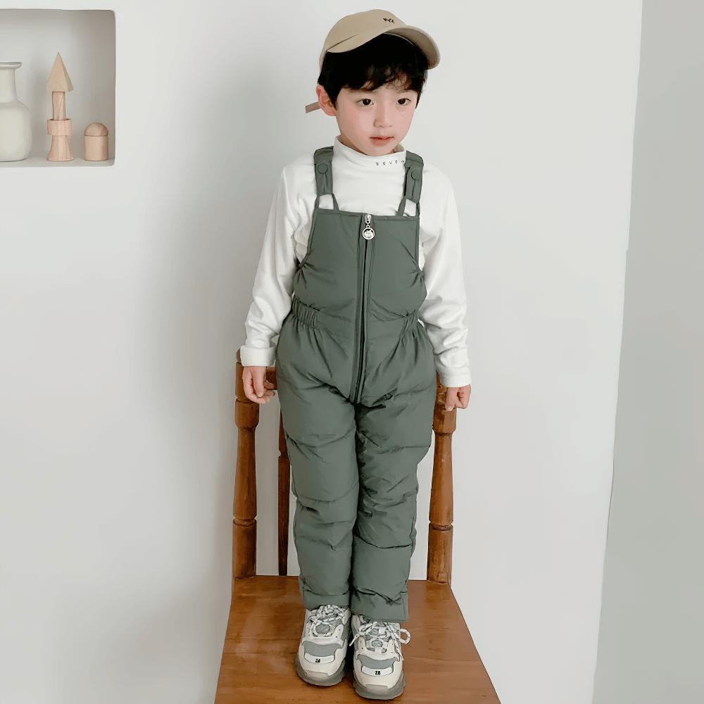 Child wearing Insulated Snow Bib Pants for Boys and Girls - SF3731, standing on a chair in warm ski overalls.