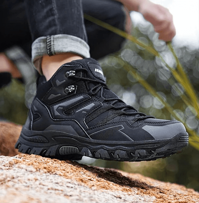 Unisex insulated leather hiking boot SF1634, black lace-up with cushioning, on rugged terrain for outdoor adventures.