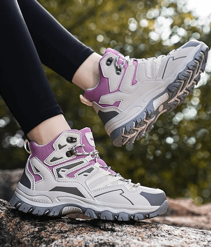 Person wearing insulated unisex leather hiking boots with cushioning on rocky terrain, showcasing waterproof and durable features.