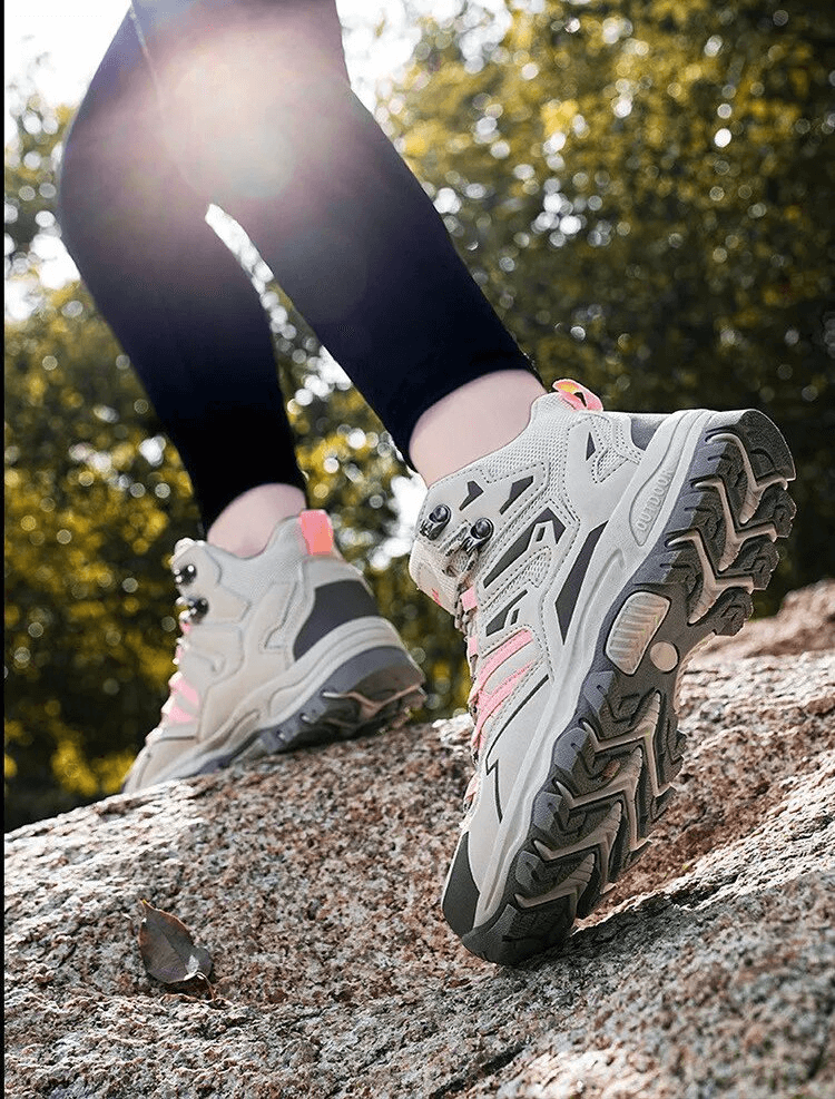 Hiker wearing Insulated Unisex Leather Hiking Boots with Cushioning on rocky terrain, showcasing waterproof protection and stability.