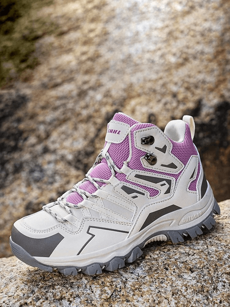 Unisex insulated leather hiking boot with cushioning, featuring microfiber and waterproof materials on rocky terrain.