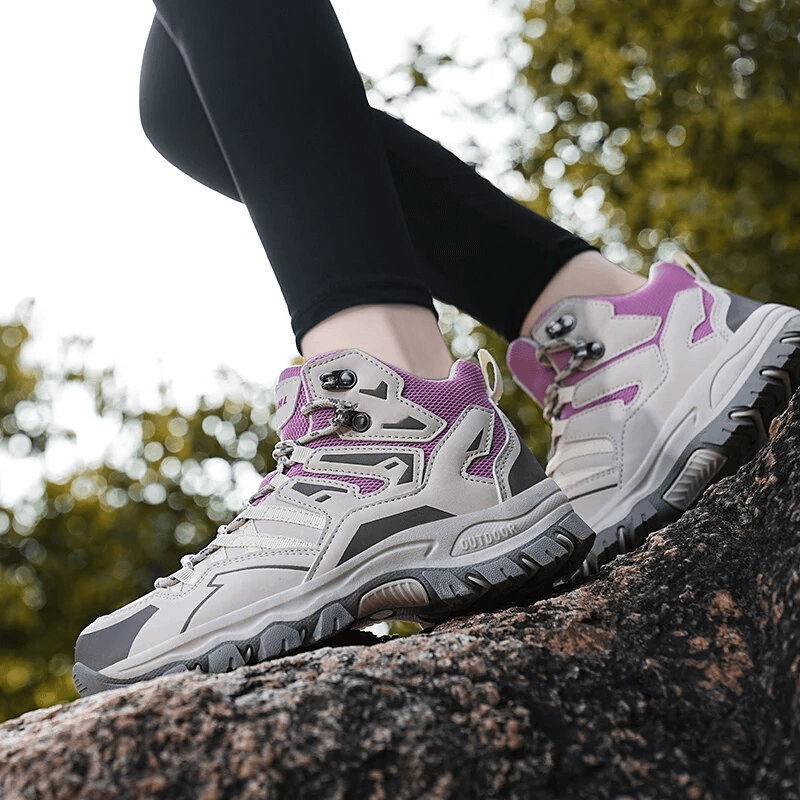 Model wearing Insulated Unisex Leather Hiking Boots with Cushioning, showcasing durability and waterproof design on a rugged rock.