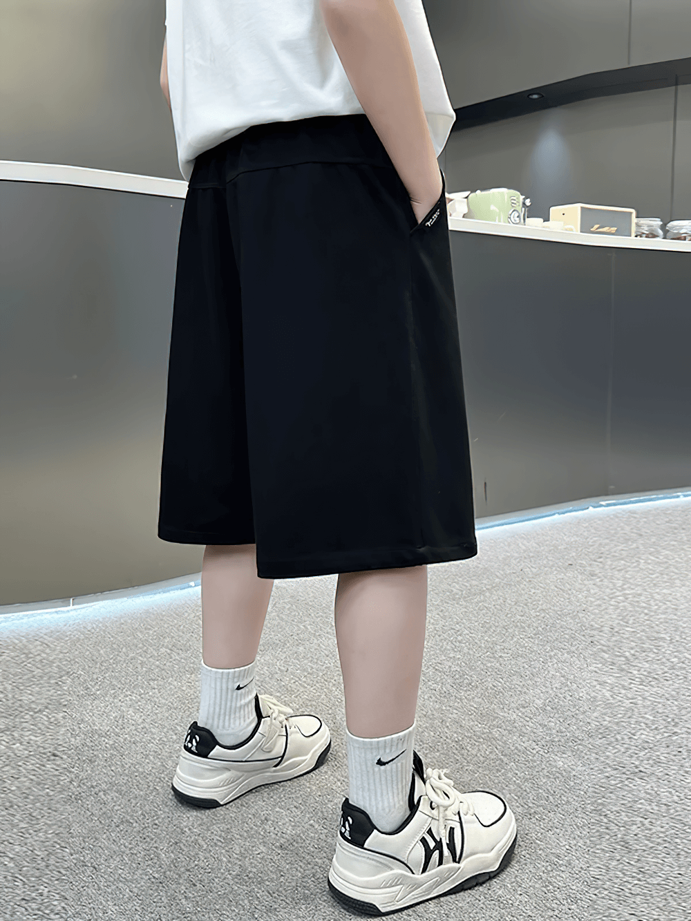 Youth wearing Kids Baggy Cotton Shorts with Graphic Print - SF3891, featuring a casual baggy fit and elastic waistband in black.