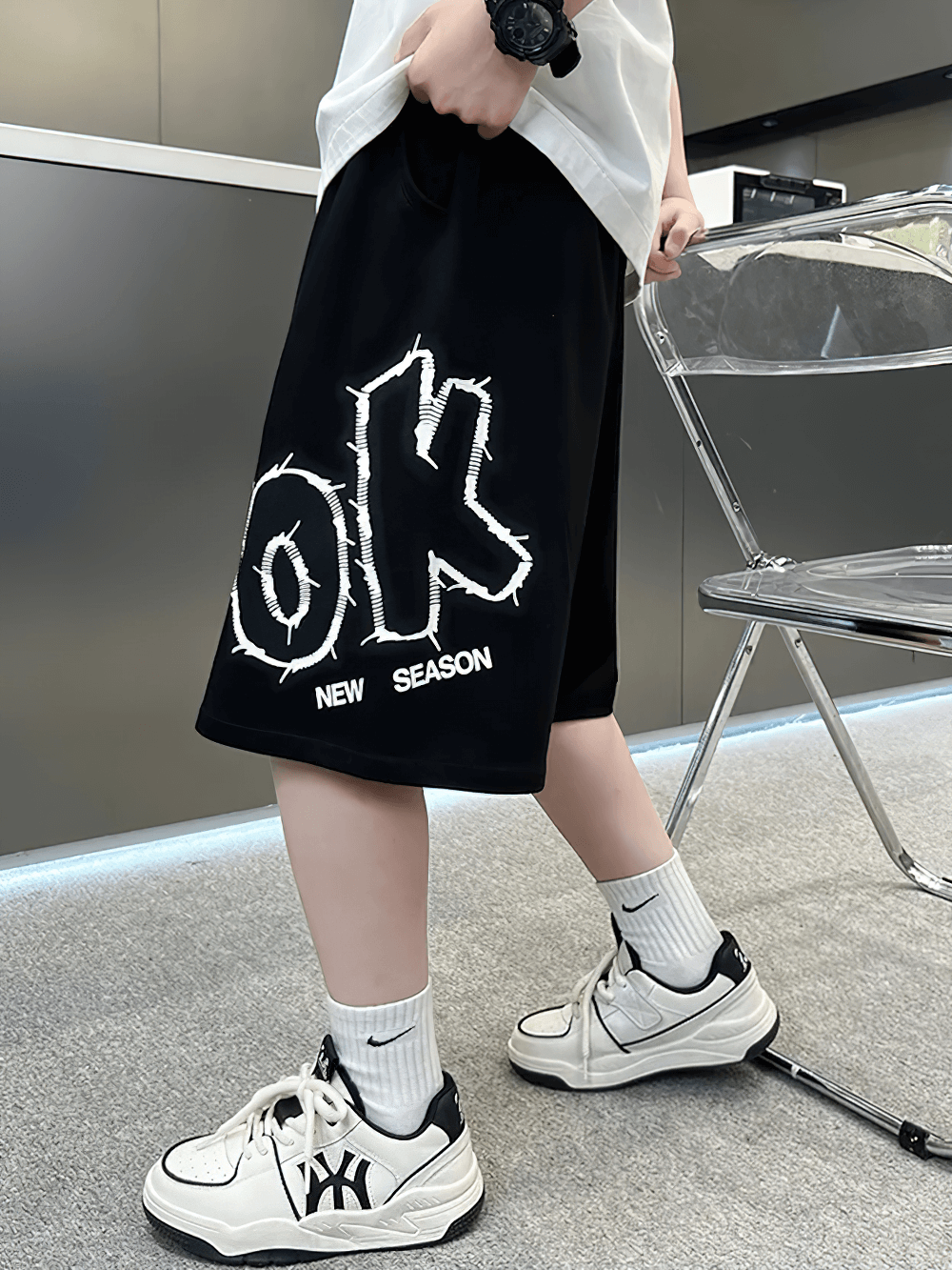 Stylish youth wearing Kids Baggy Cotton Shorts with Graphic Print - SF3891, showcasing bold lettering and casual style.