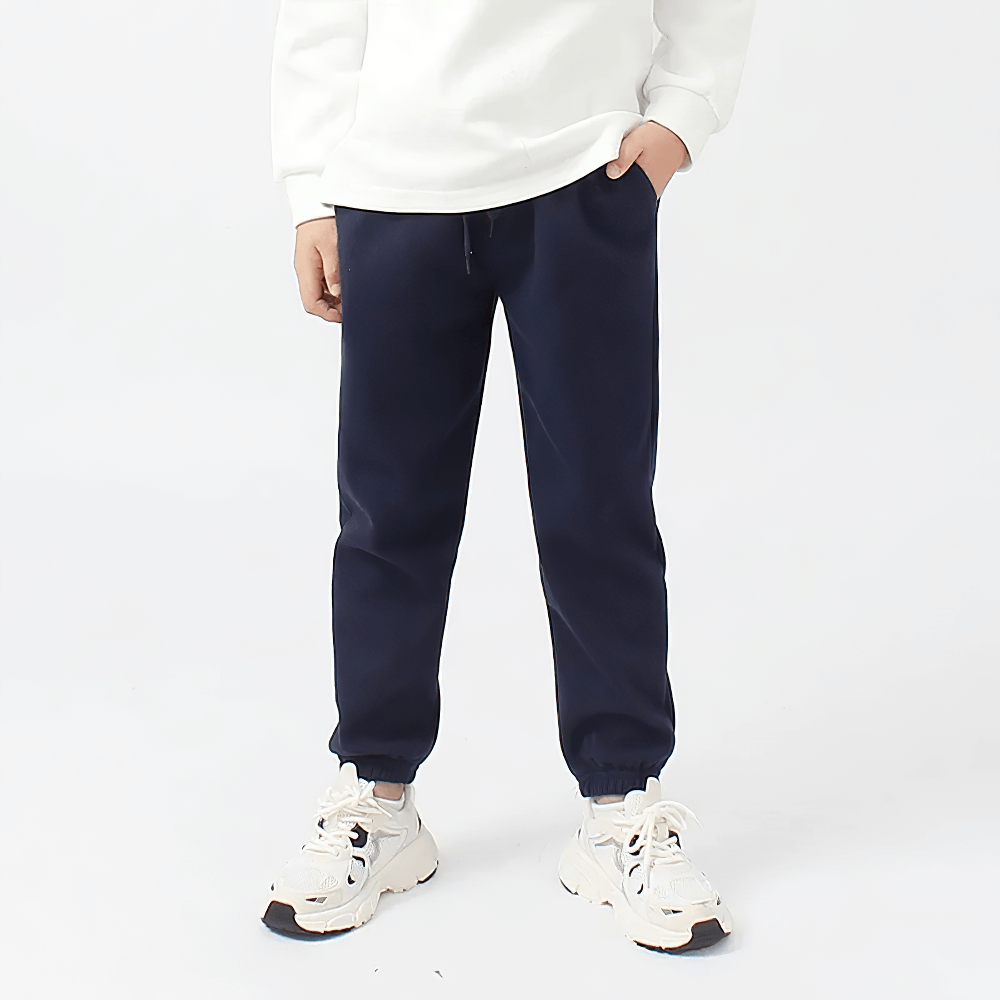 Child wearing Kids Casual Sports Jogger Pants with Pockets - SF3612, showing navy joggers with elastic waistband and side pockets.