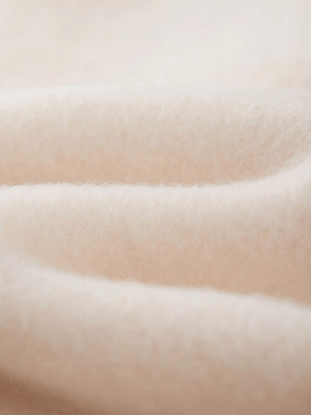 Soft white fluffy fabric texture ideal for cozy clothing, blankets, and plush interiors.