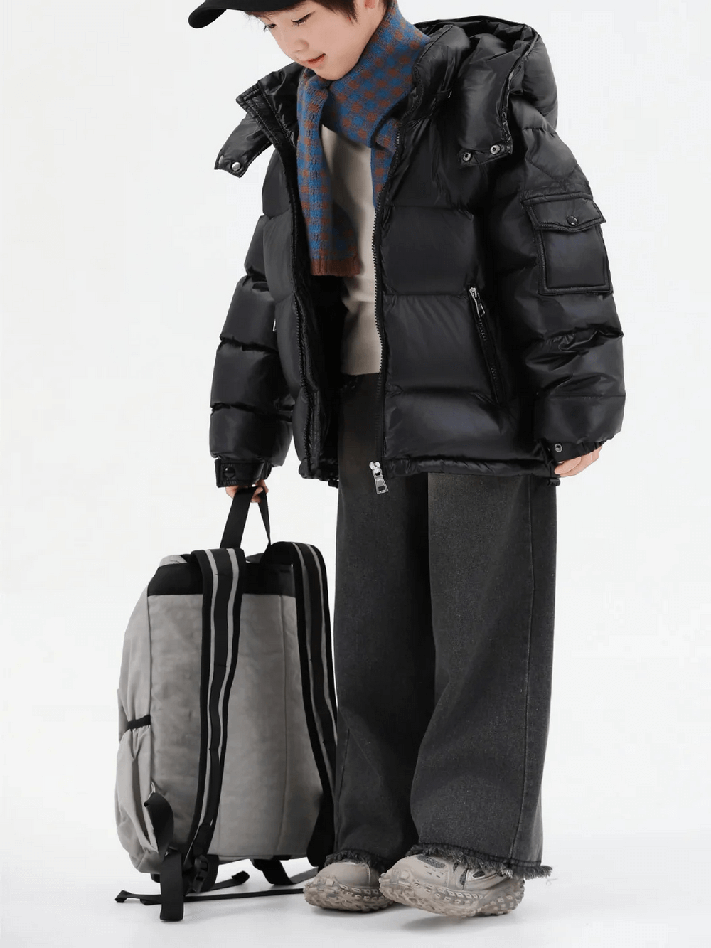 Young girl wearing Kids Duck Down Jacket with Hood and Zipper - SF3515, dressed warmly for winter, pulling a suitcase.