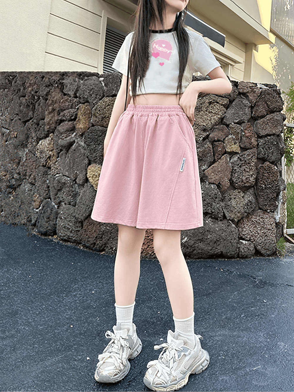 Girl wearing Kids Elastic Waist Loose Shorts with Pockets - SF3870 in pink, looking stylish with casual top and sneakers.