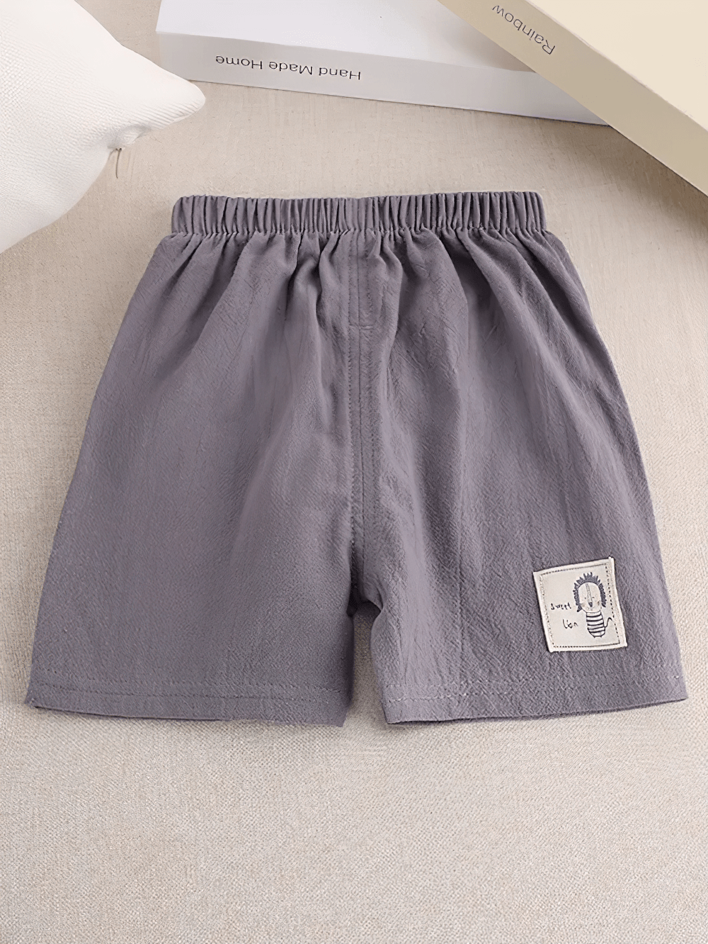 Kids Lightweight Shorts with Cute Patch Detail - SF3755 in grey with elastic waistband and white side stripe on beige background.