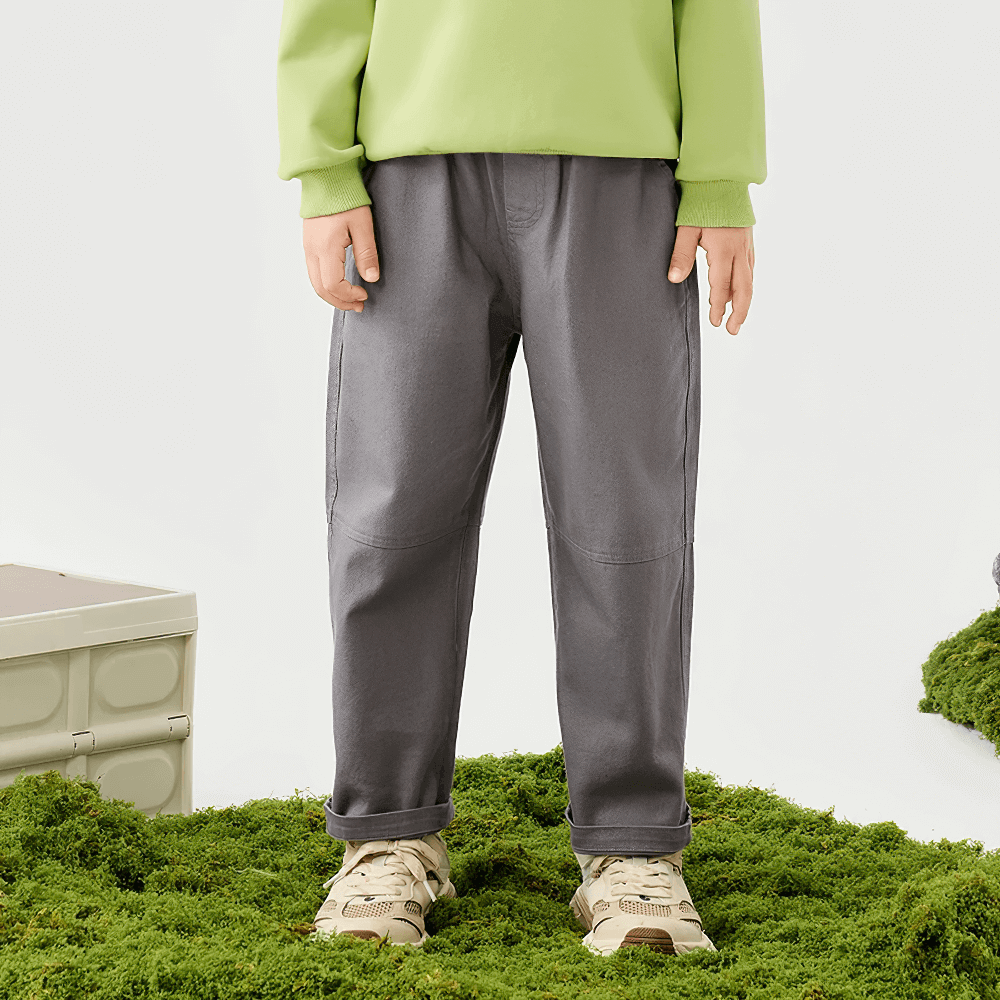 Child wearing Kids Loose Sport Trousers with Elastic Waist - SF3801, standing on grass, showcasing soft cotton fabric and relaxed fit style.