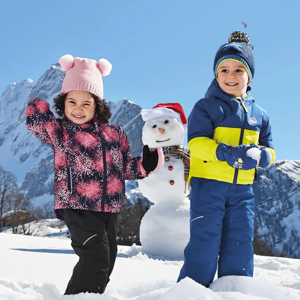 Kids Ski Jacket with Hood and Elastic Cuffs - SF3580 on happy children playing in snow with a snowman and mountains in the background.