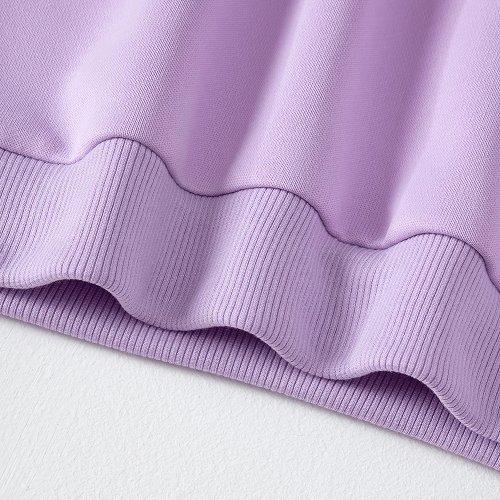 Close-up of kids' solid lavender sweatshirt hem showcasing comfortable and durable polyester fabric.