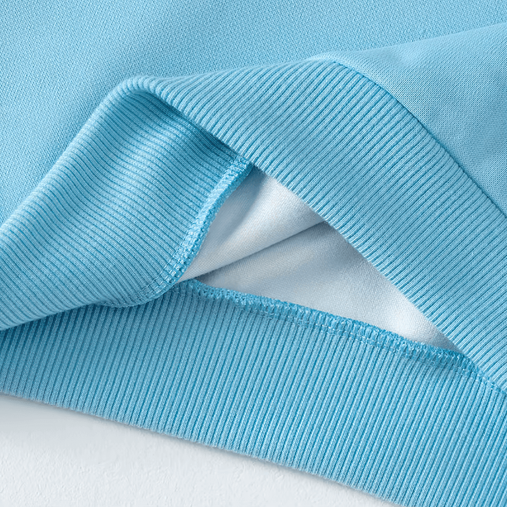 Close-up of kids' blue solid color sweatshirt fabric showing ribbed texture and durable polyester material, perfect for everyday wear and sports.