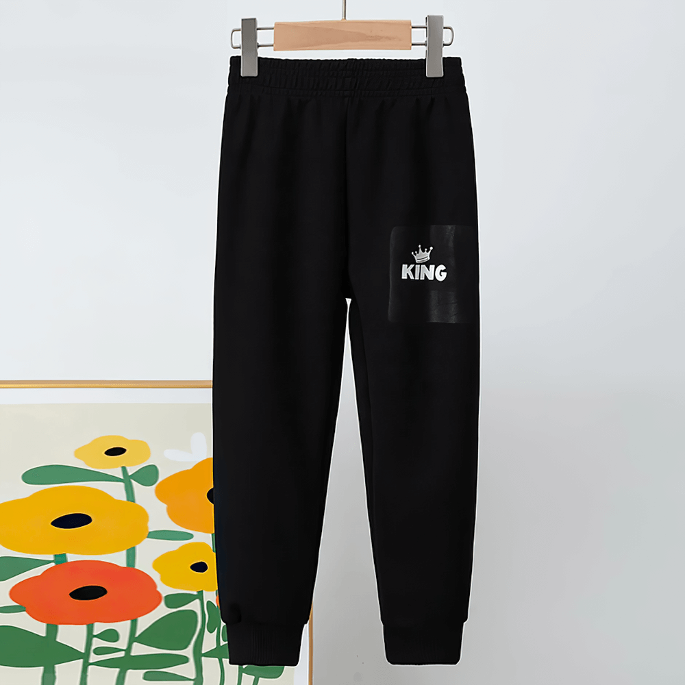 Kids Sport Jogger Sweatpants with Elastic Waist - SF3888, black jogging pants hanging on wooden hanger, perfect for active children.
