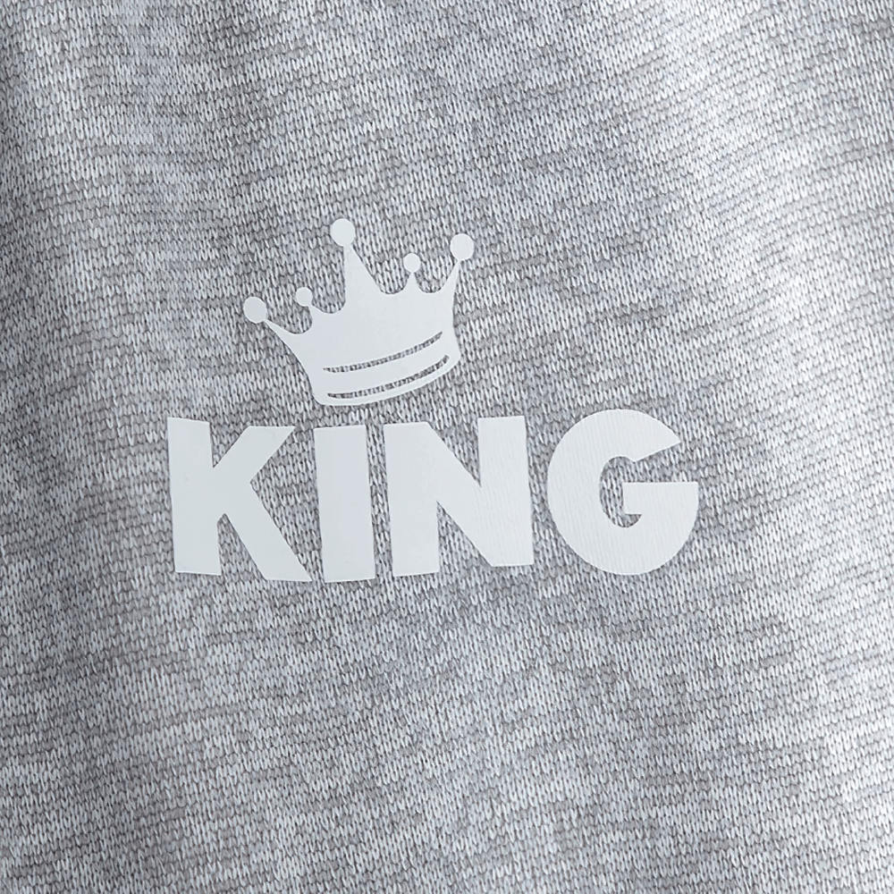 Close-up of a gray fabric with 'KING' and a crown graphic, perfect detail on cozy wear.